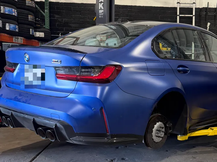 BMW up on a lift with the wheels off at Top Speed Auto Center, Van Nuys
