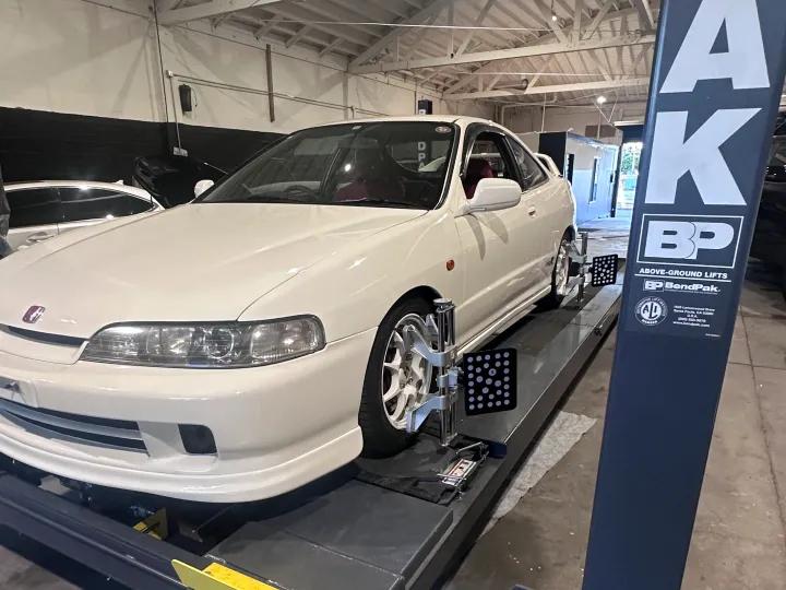 White coupe on a four-post lift at Top Speed Auto Center, Van Nuys